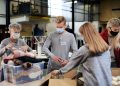 Group of volunteers working in community charity donation center, food bank and coronavirus concept.