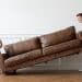 A person lifting a couch Description automatically generated