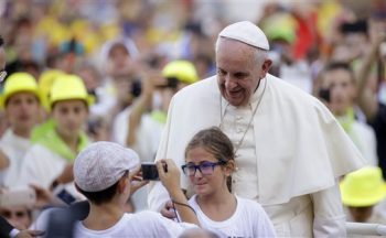 FILE - In this Tuesday, Aug. 4, 2015, file photo, Pope Francis poses for a photo as he arrives in St. Peter's Square at the Vatican for an audience with with Altar boys and girls. Francis thrills Democrats with his teachings on climate change, social justice and immigration. At the same time, his message on life and the Catholic Church's traditional opposition to abortion comfort Republicans. Both Democrats and Republicans are looking forward to Francis' remarks to Congress next month. (AP Photo/Gregorio Borgia, File)