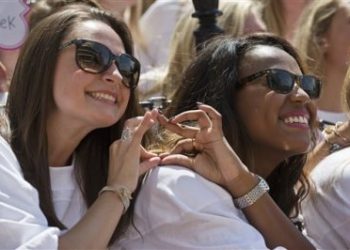 The University of Alabama Phi Mu's newest sorority members, Anna Misemer, left, and Marissa Lee, right, make their hand symbol during sorority Bid Day on Saturday, Aug. 16, 2014, in Tuscaloosa, Ala. The university became embroiled in controversy in 2013 after the student newspaper reported some white sororities had rejected blacks as new members because of race. At the end of 2014 sorority recruitment, black women made up 1 percent of new members. (AP Photo/Brynn Anderson)