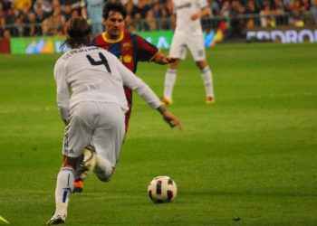 Messi and Ramos fighting for a ball in a Clasico