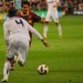 Messi and Ramos fighting for a ball in a Clasico